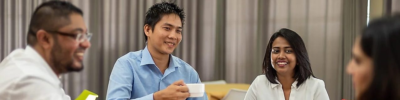 Emplyees at a desk smiling