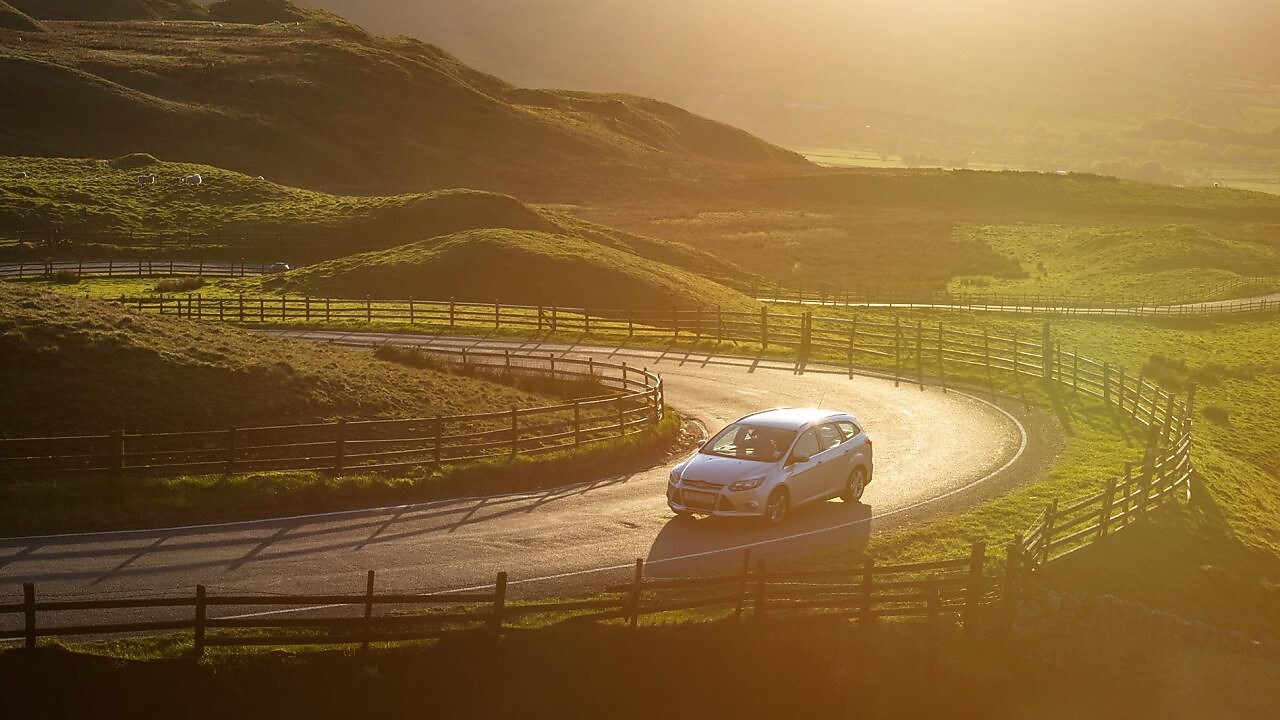 car driving in green field 