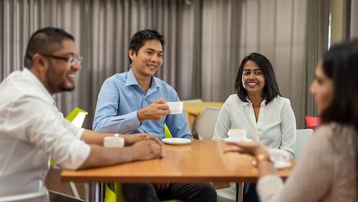 Emplyees at a desk smiling