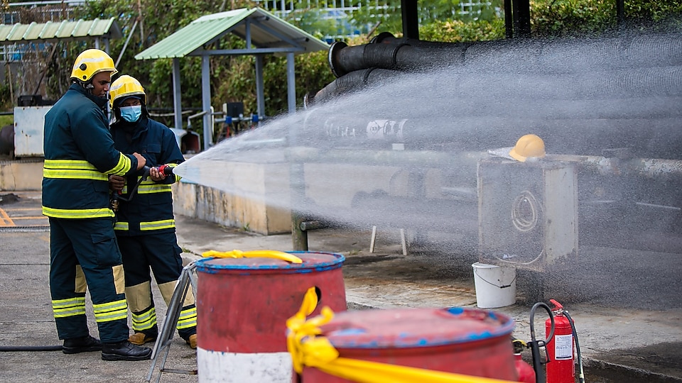 Two workers spraying water