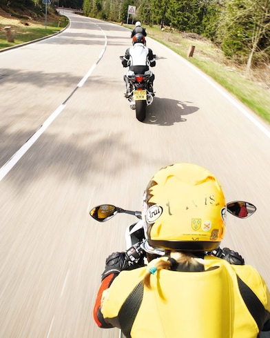 Three motorbikes being ridden along a mountain road