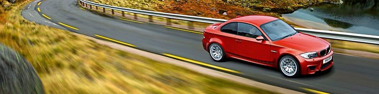 Red sedan driving on the road in Norway