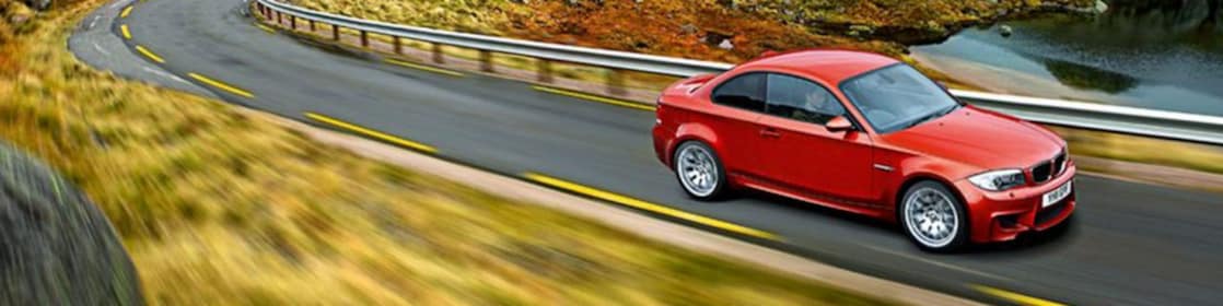 Red sedan driving on the road in Norway
