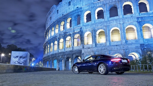 Car parked outside of the Colosseum in Rome at night