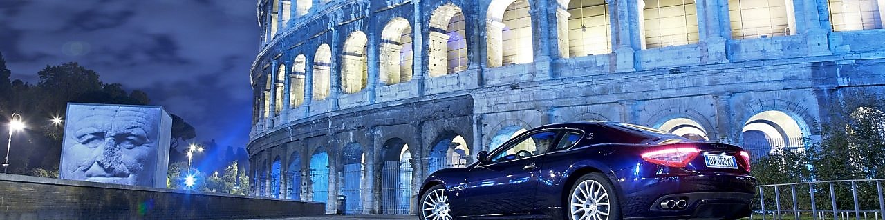 Car parked outside of the Colosseum in Rome at night