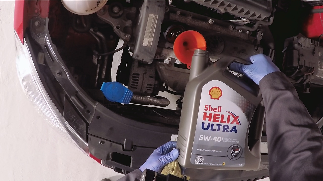 Hands pouring shell helix ultra fresh oil