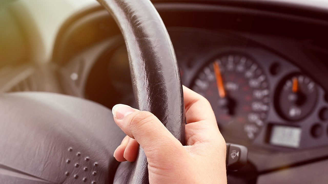 Hand holding a steering wheel