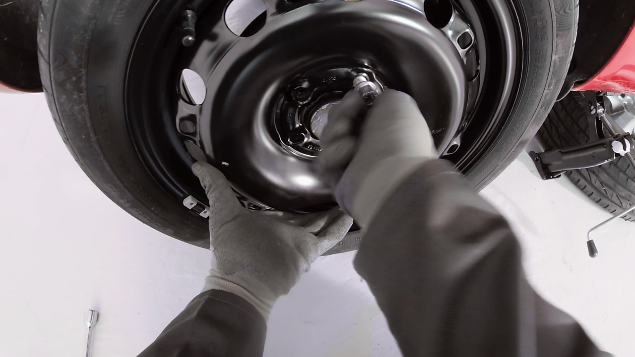 hands screwing the wheel nuts