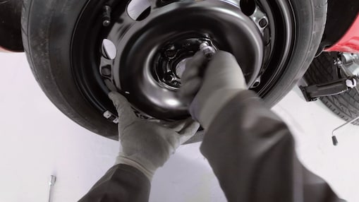 hands screwing the wheel nuts