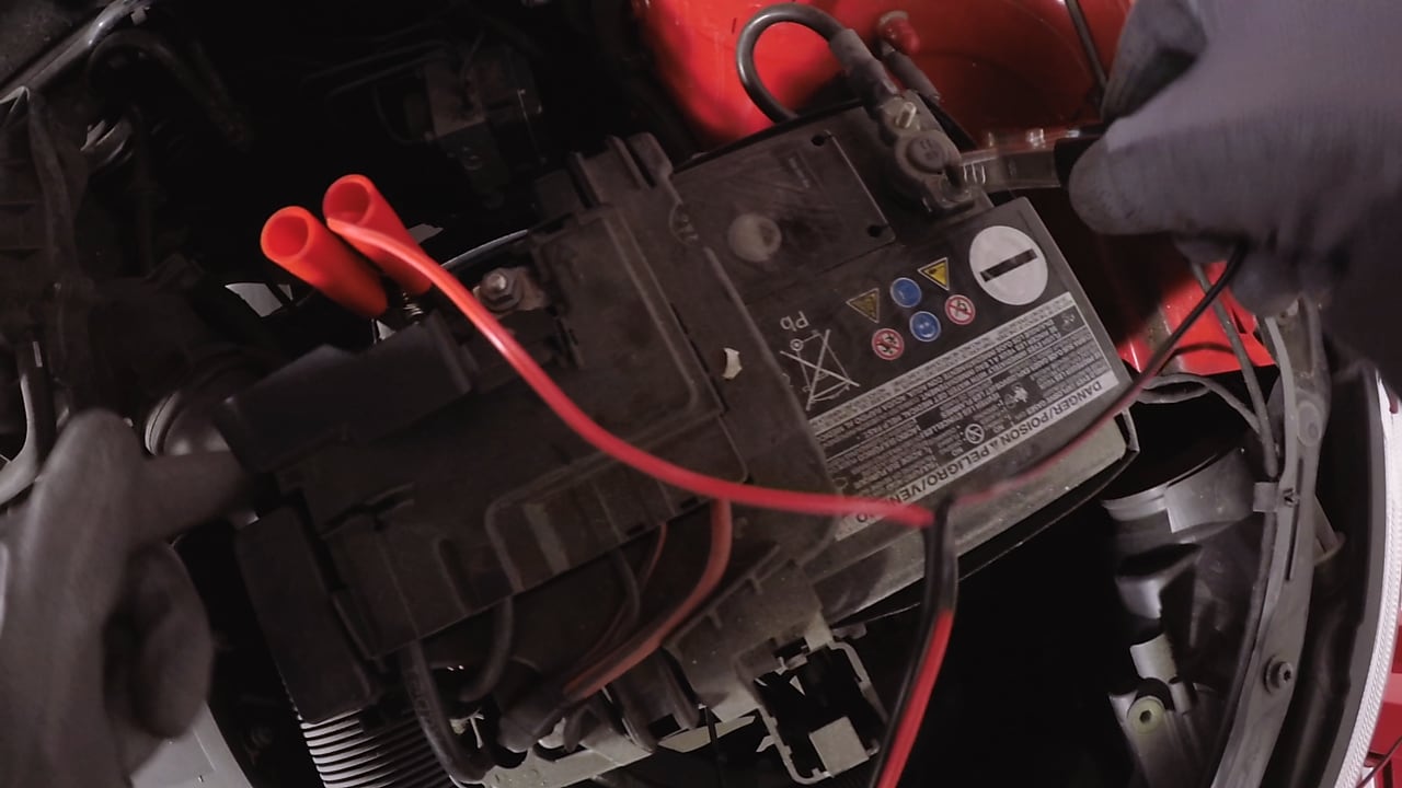 hands connectig a car battery to a charger