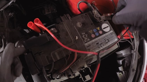 hands connectig a car battery to a charger