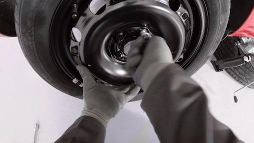 hands screwing the wheel nuts