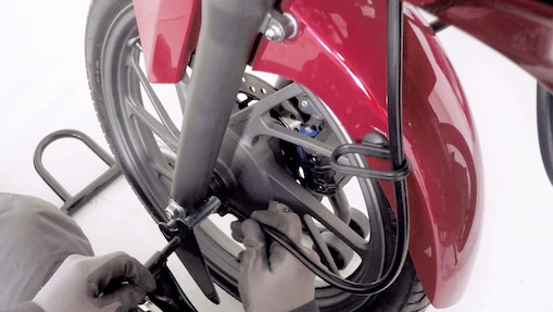 hands fitting a new tyre to a motorcycle