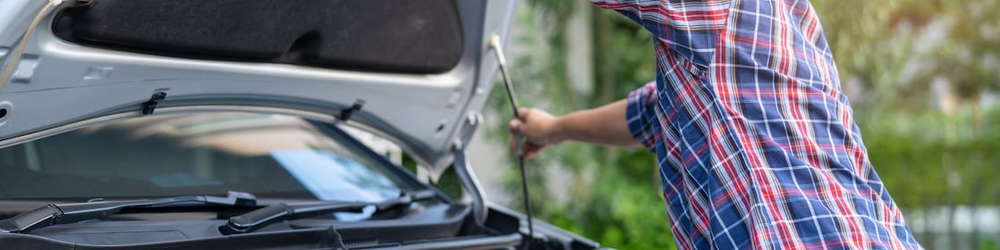 woman opening hood of car