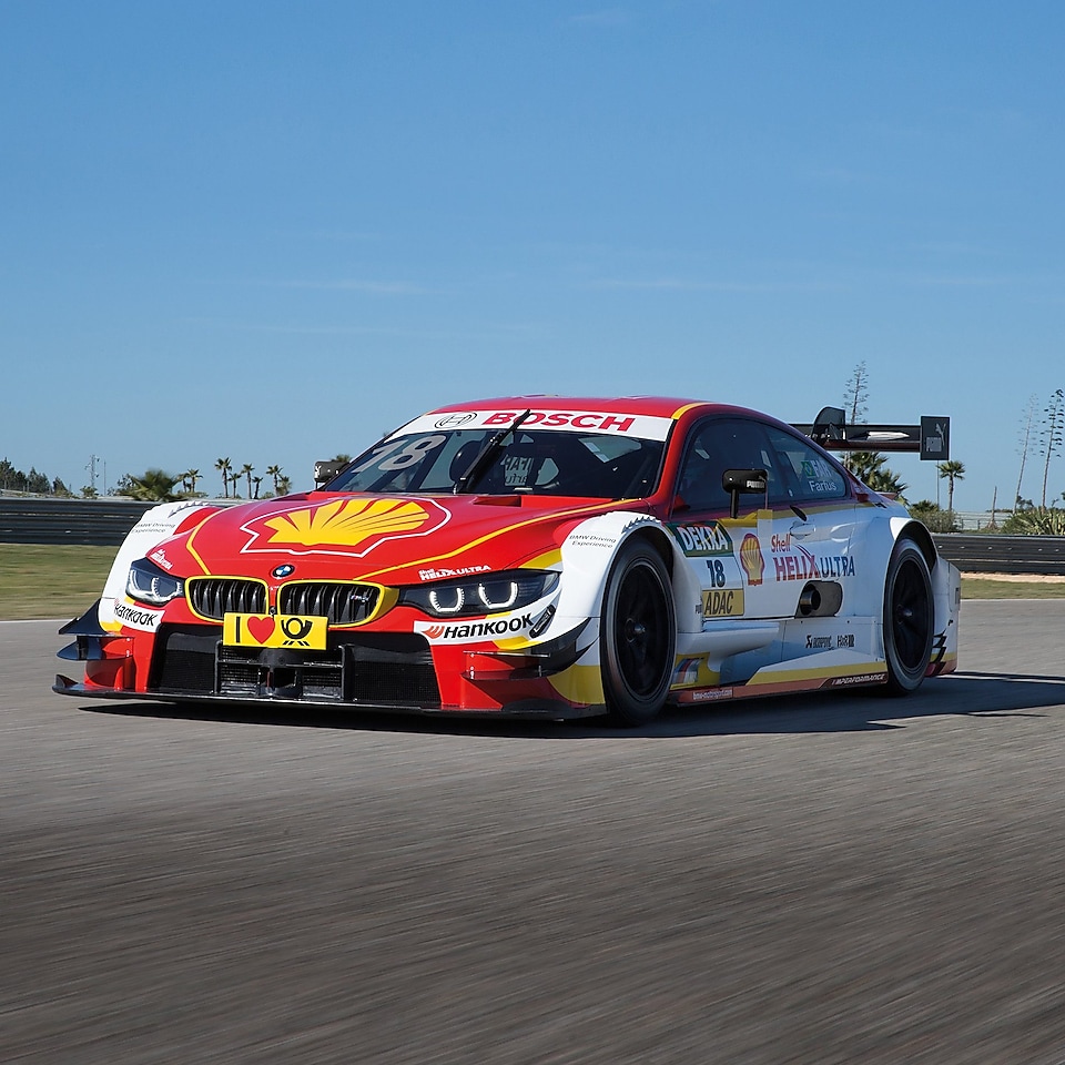 A red and white BMW race car sits on the track, exemplifying the Shell Helix Ultra and BMW’s Premium Technology Partnership