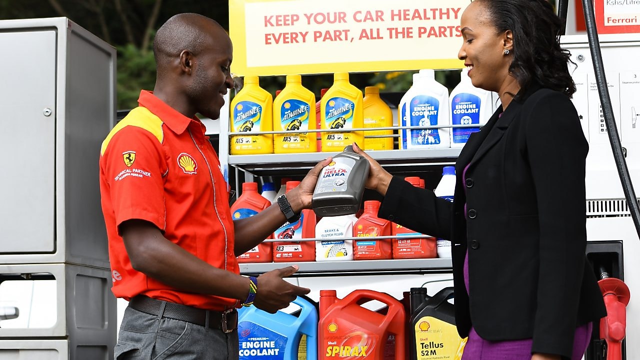A Service champion helps a lady to find a product on the forecourt