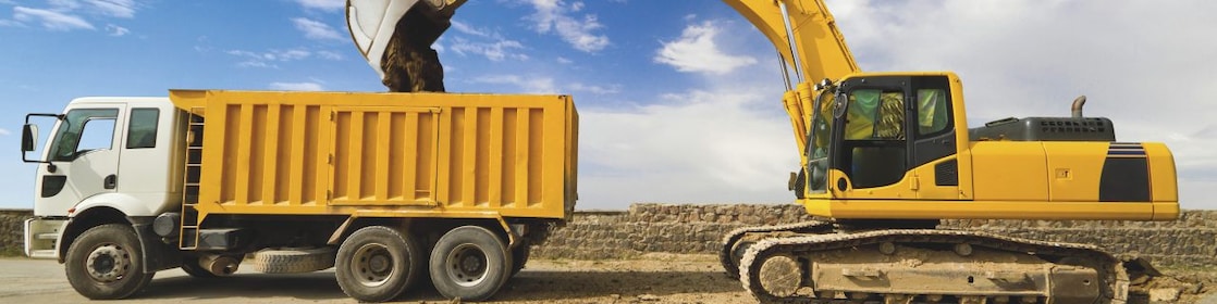 yellow excavator loading mud into a truck
